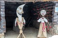 Dolls in MeteÃâ i mumming masks and costumes of Moon and Sun standing at log granary